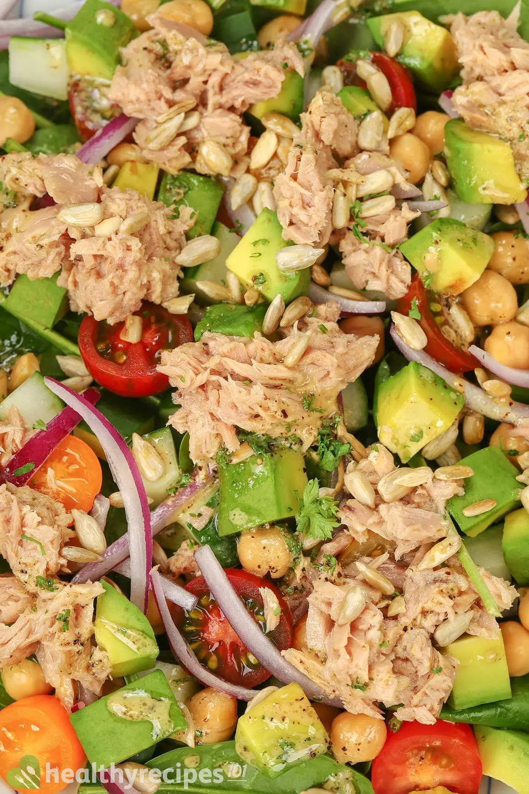 a close-up shot of avocado cubes and canned tuna decorated by sun flower seeds