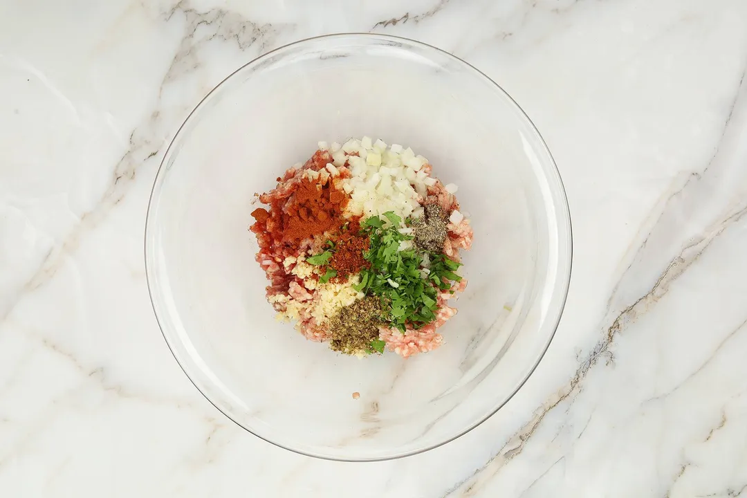 ground pork, ground beef, chopped onion and spices in a bowl