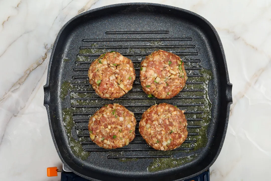 four patties on a grill-pan