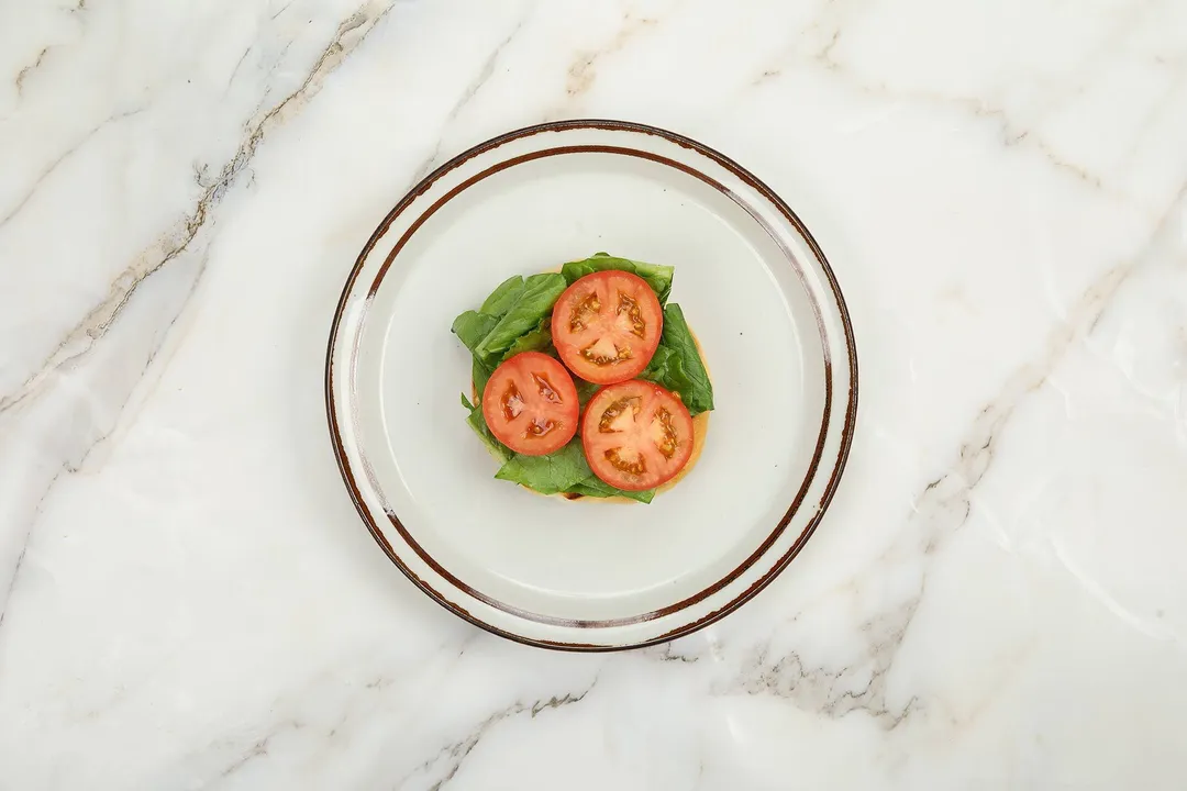 three tomato slices bed on lettuce on a plate