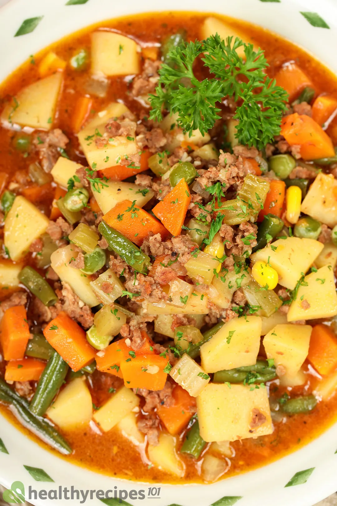 top view of a bowl of ground beef soup with potato carrot and beans