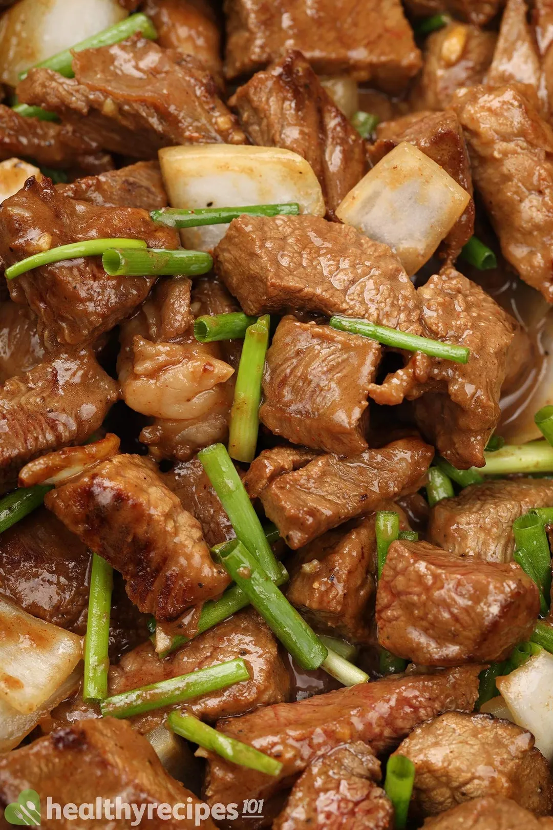 close-up shot of cooked beef tenderloin cubed with chopped scallions and onion