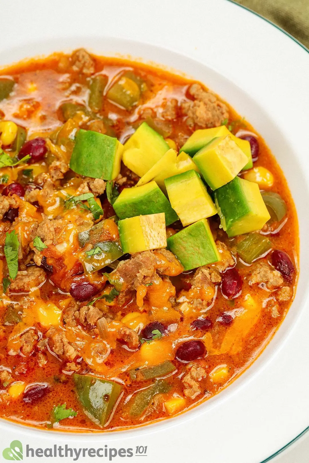 close-up view of a bowl of taco beef soup with cubed avocado