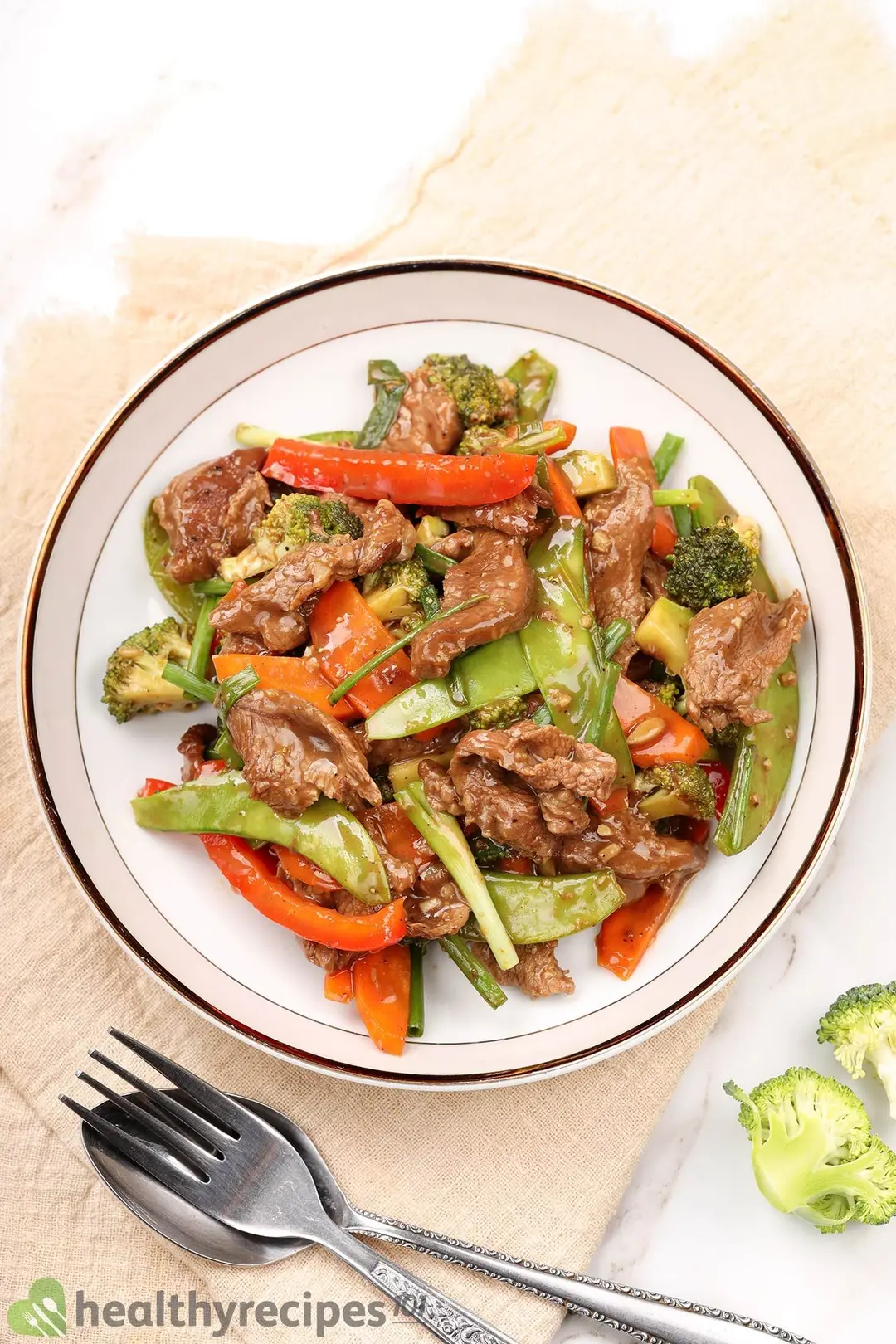 a plate of cooked beef and green bean, carrot, pepper, broccoli and scallion