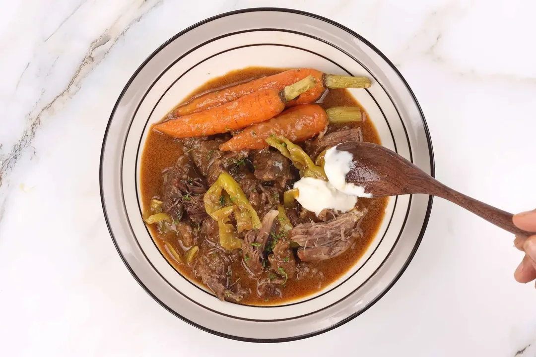 Plate with beef gravy Greek yogurt and herbs