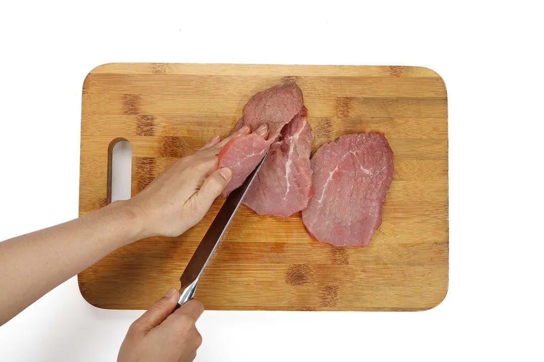 slicing beef on a cutting board