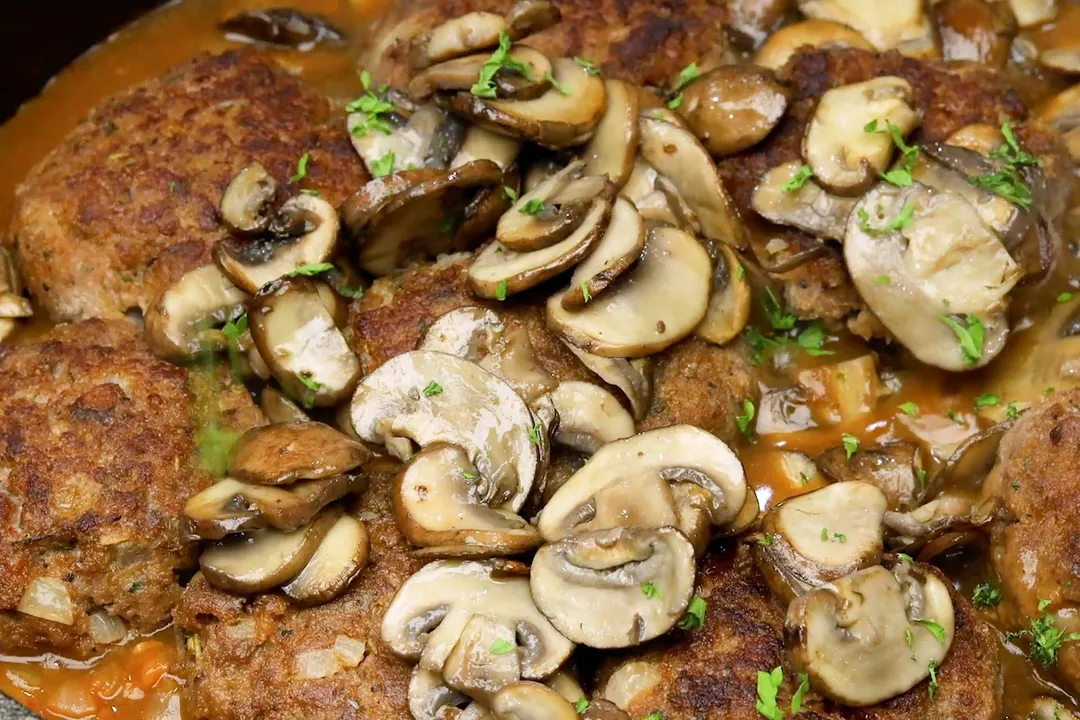 cooked cremini mushroom on cooked beef patties