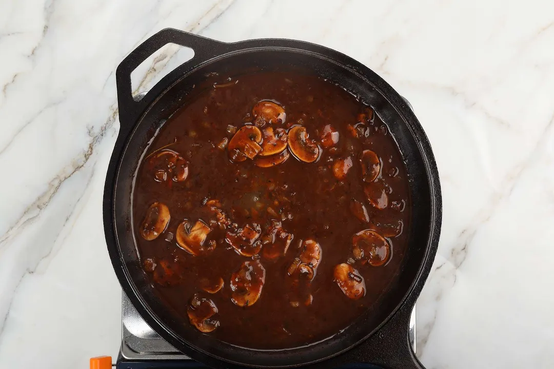 mushroom red wine sauce cooking in a cast iron skillet