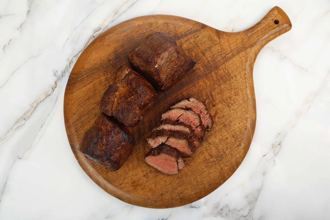 beef tenderloin and sliced beef on a cutting board