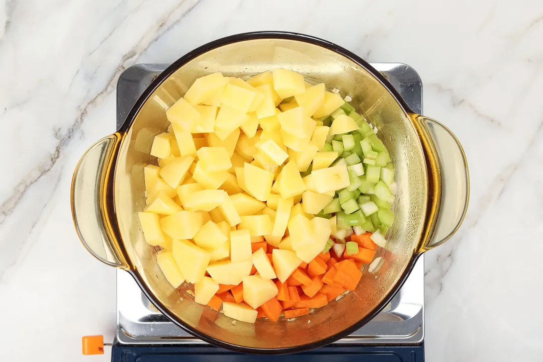 potato cubes, carrot and celery in a glass pot