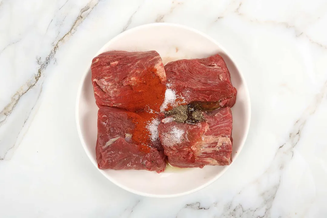 four beef tenderloin with seasoning on a plate