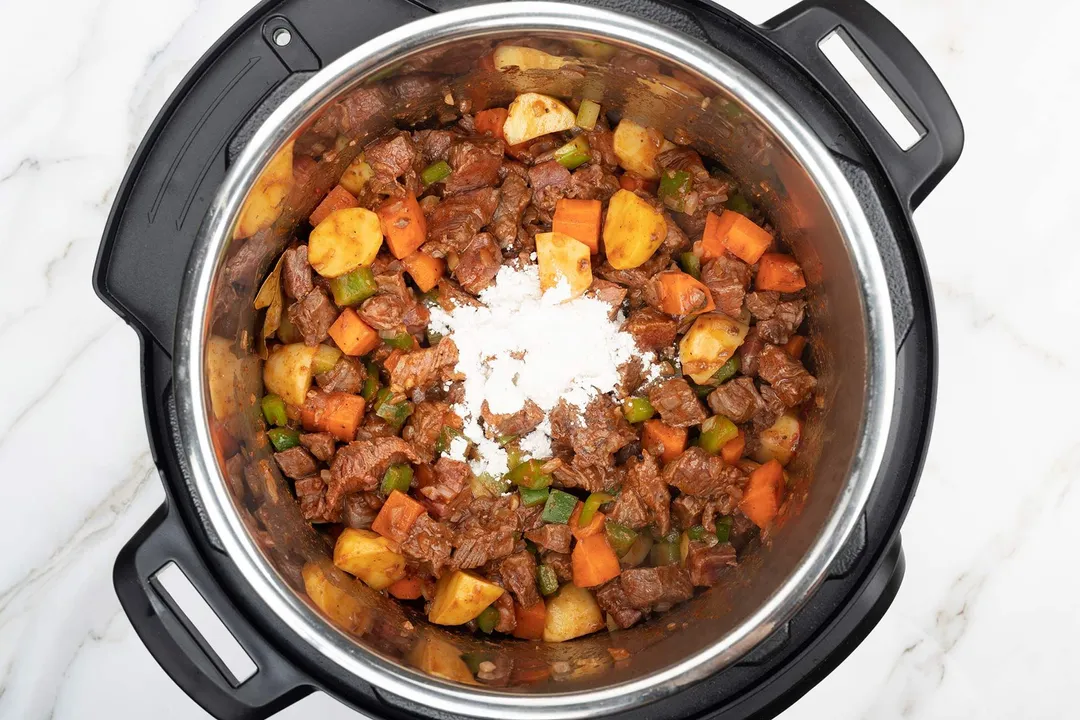 beef chunk, potato diced, carrot diced, pepper diced and all-purpose flour cooking in an instant pot