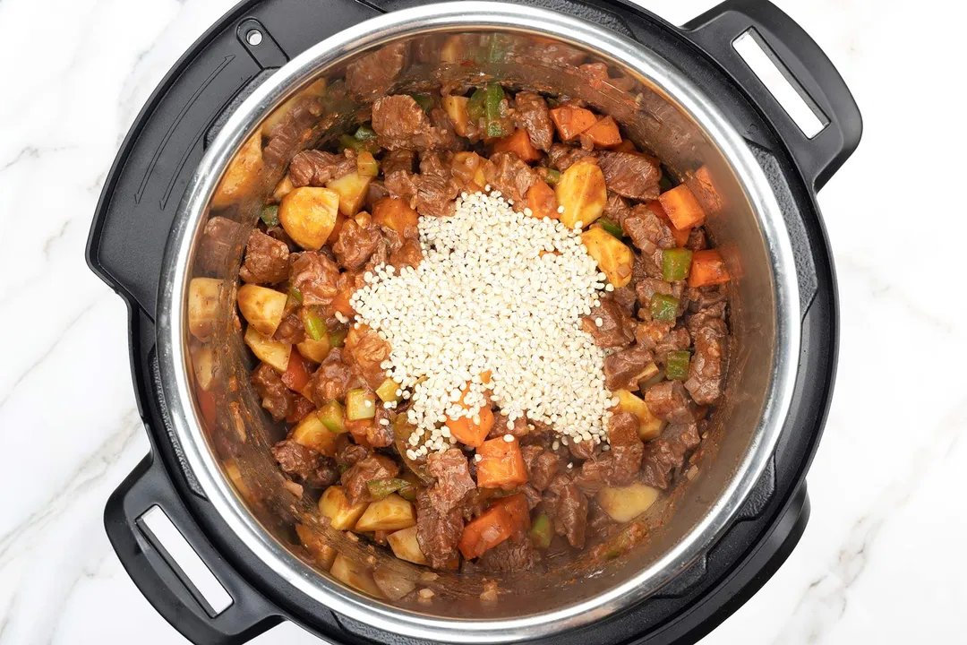 instant pot of beef chunk cubed, pepper diced, carrot diced and potato diced and barley