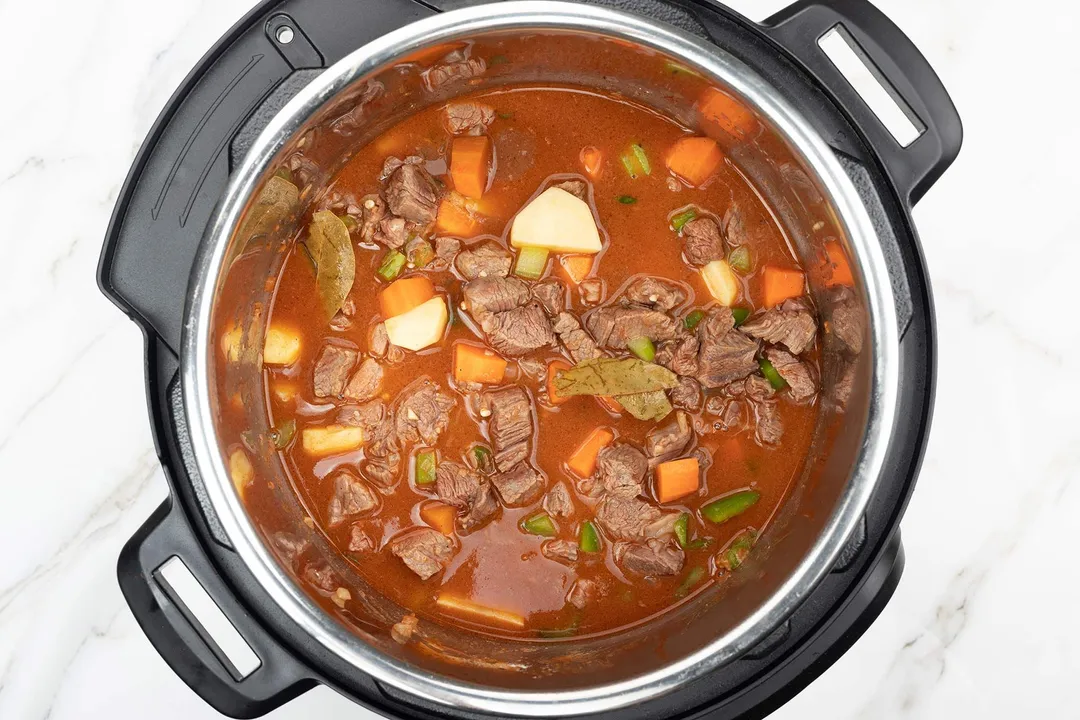 an instant pot cooking beef, potato, carrot