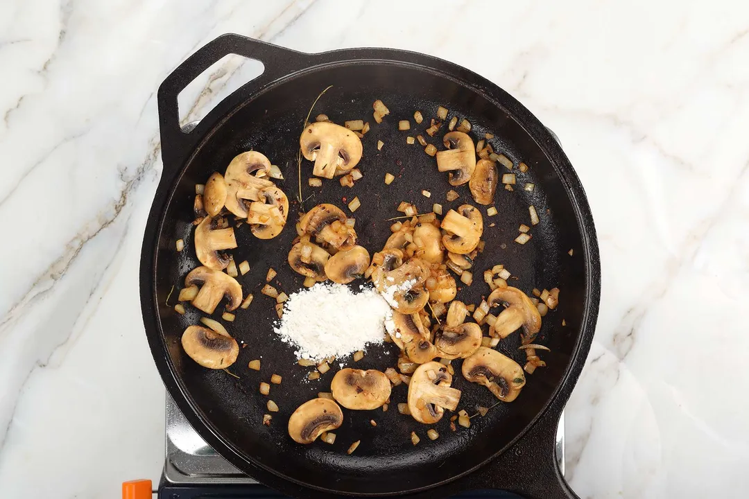flour and cooked mushroom in a cast iron skillet