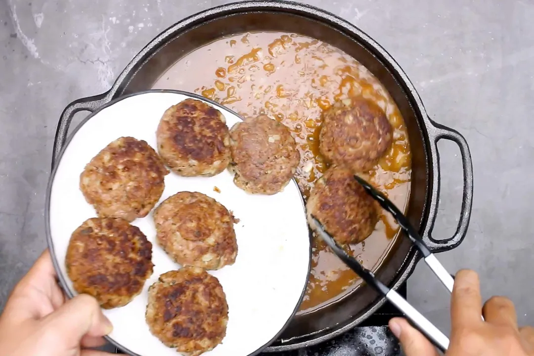 Adding the beef patties into cast iron skillet