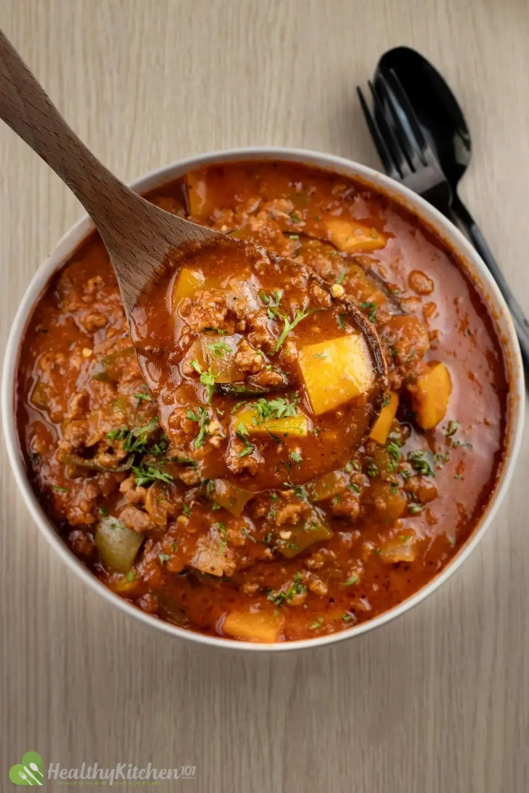 A bowl of brown soup filled with pepper chunks meat, and other ingredients