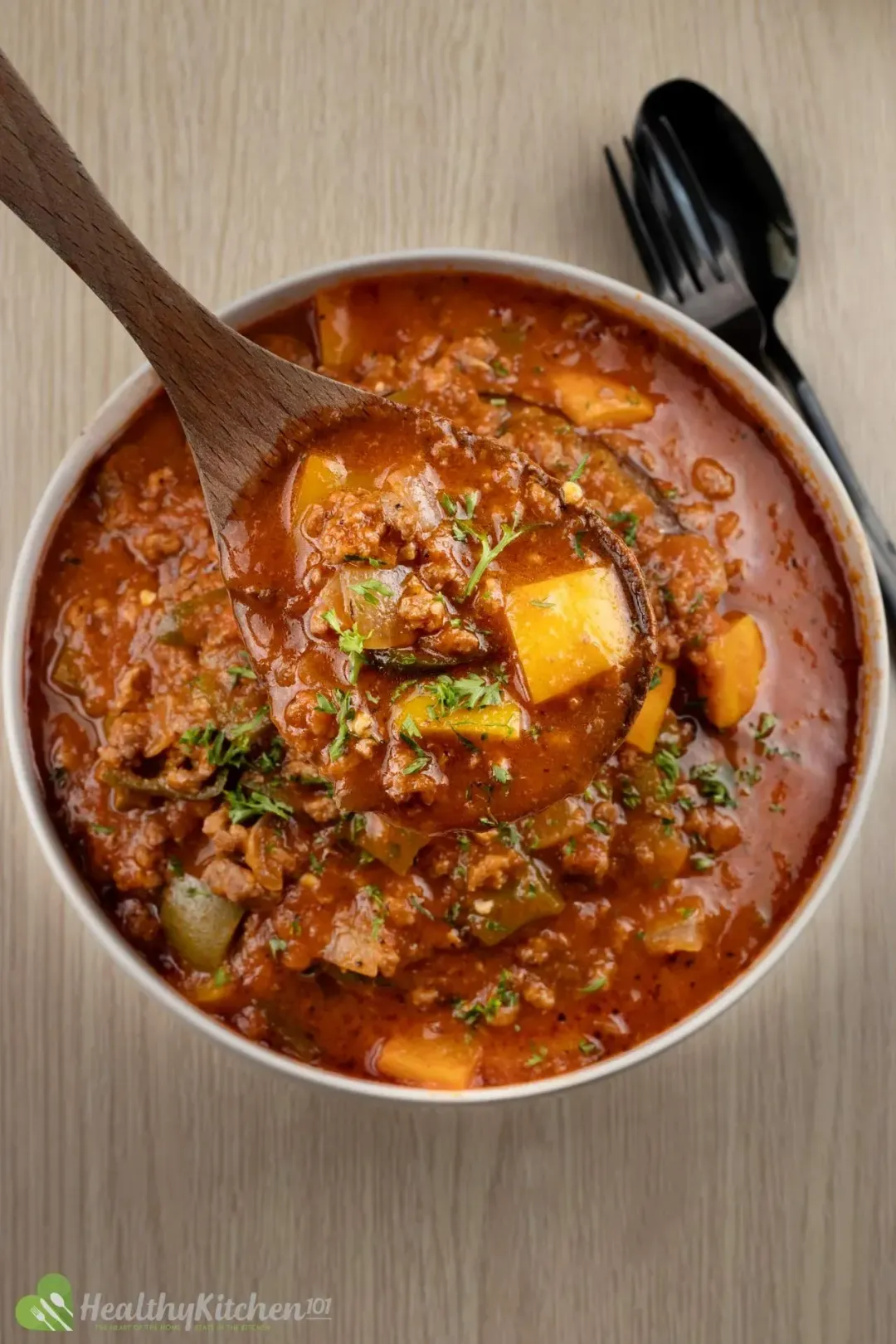 A bowl of brown soup filled with pepper chunks meat, and other ingredients