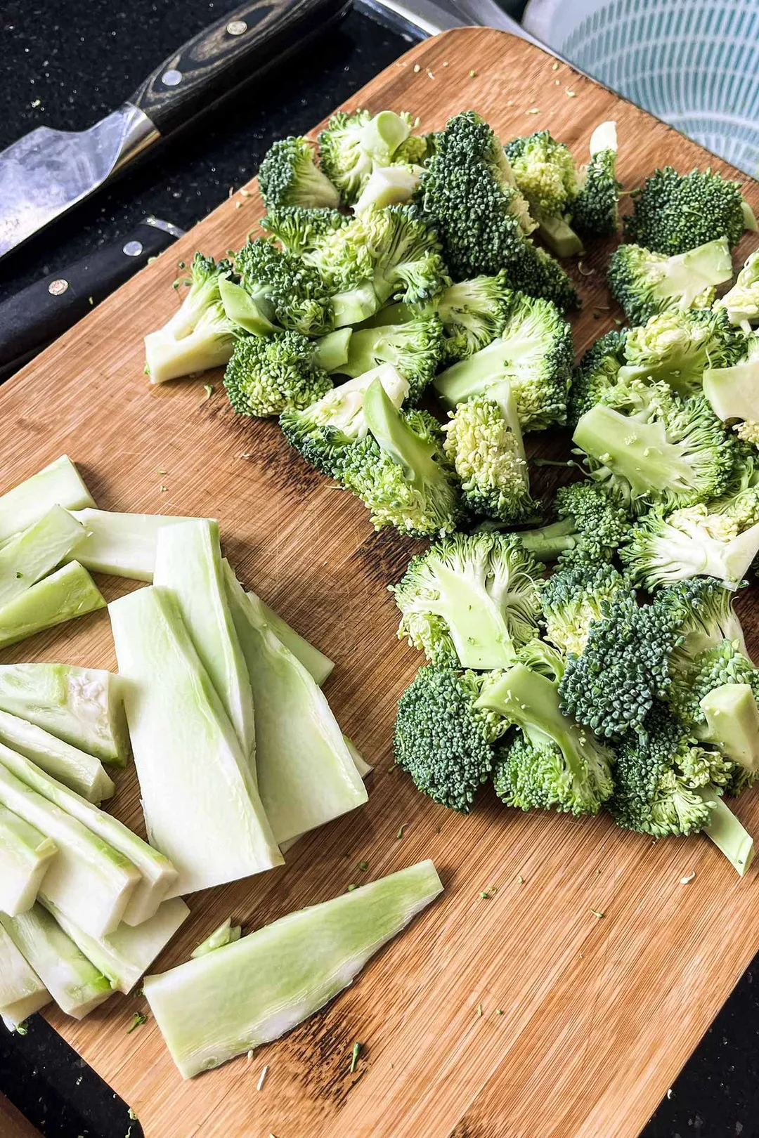 broccoli florets and stalk sliced on a bamboo cutting board