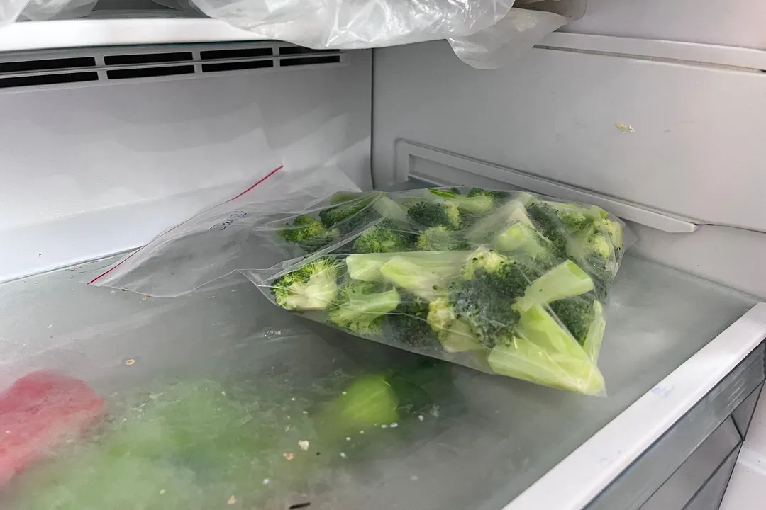 a plastic bag of broccoli florets in a freeze