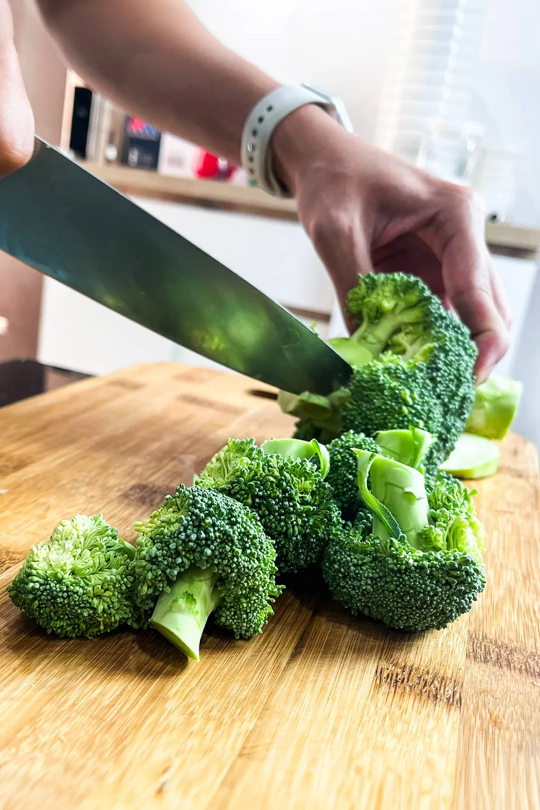 cut broccoli into florets on a cutting board by a knife