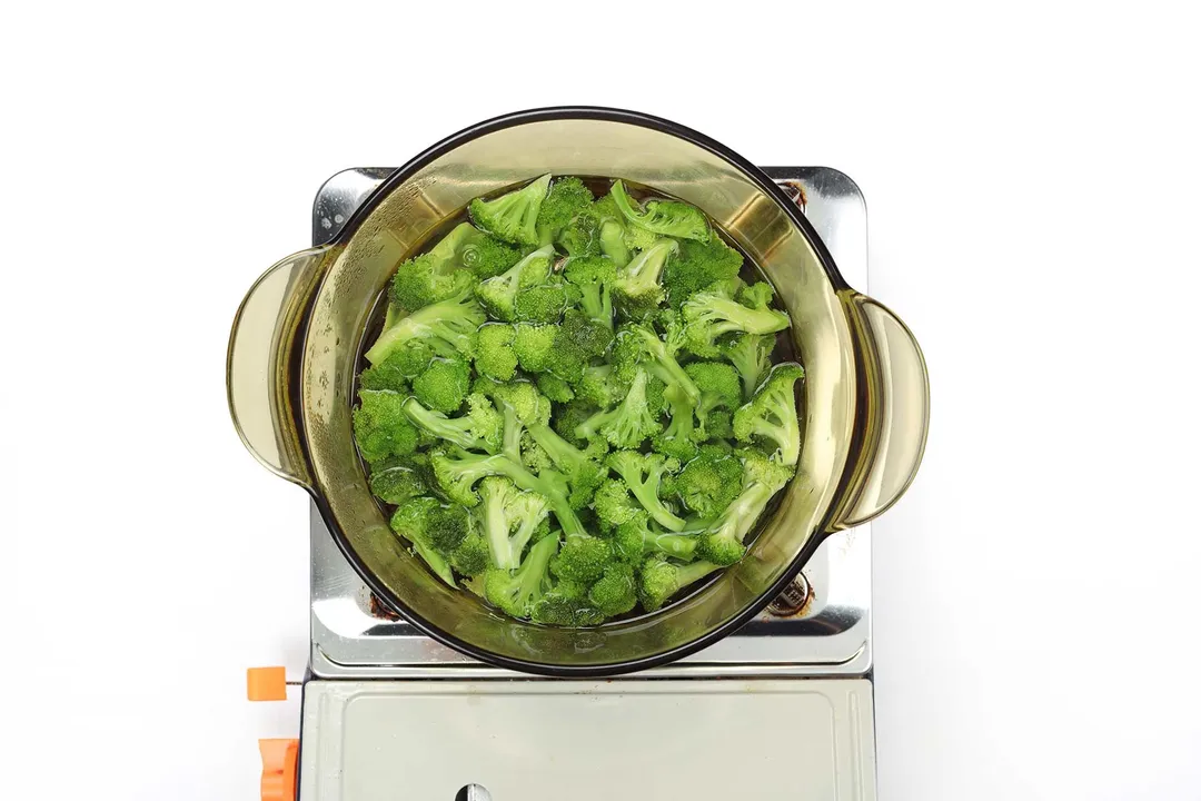 A glass saucepan filled with fresh and bright green broccoli florets