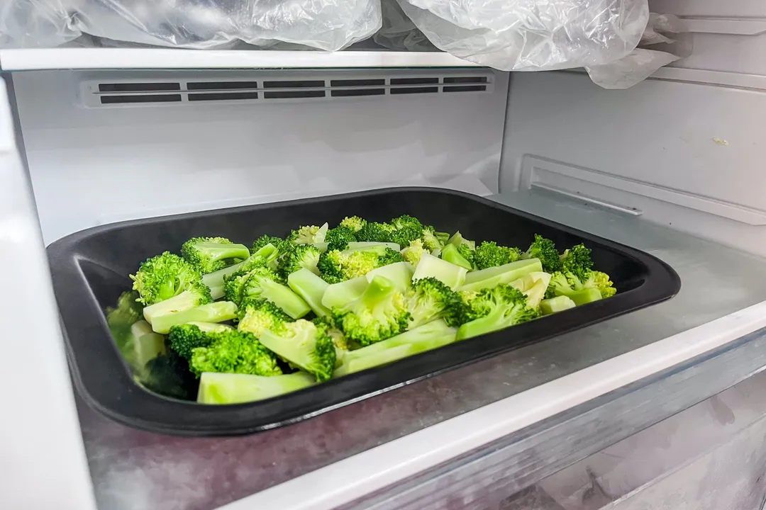 a tray of broccoli florets in a fridge