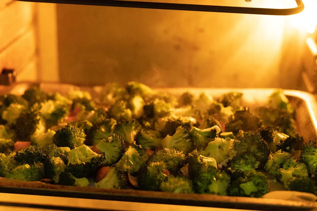 An oven roasting broccoli florets and other vegetables.