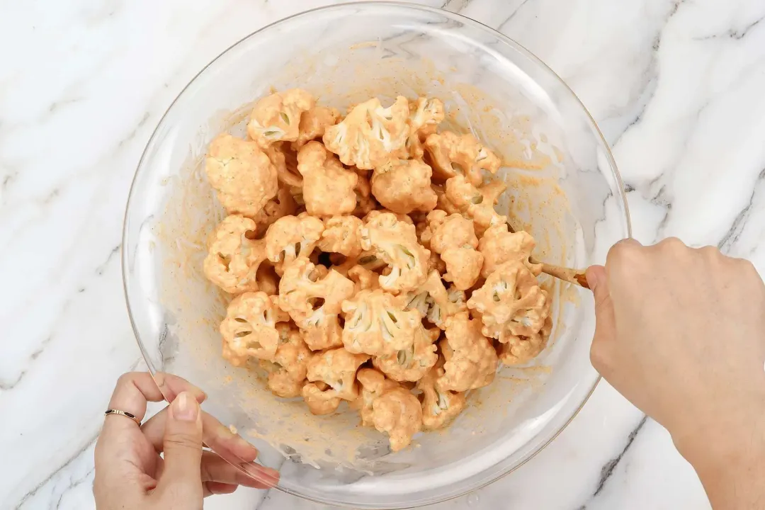 Add cauliflower to the seasoning mixture and toss