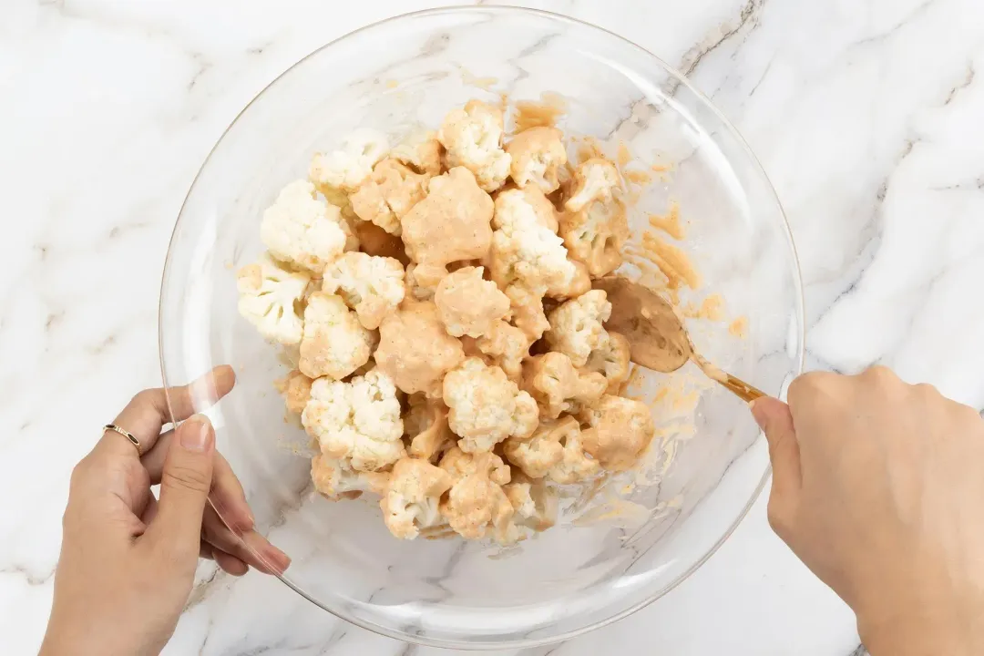 Dip and toss the cauliflower florets in the coating mixture