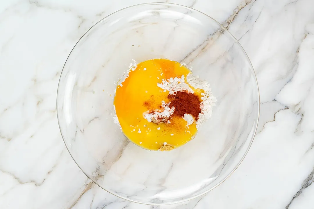 mixing flour, egg, paprika in a glass bowl