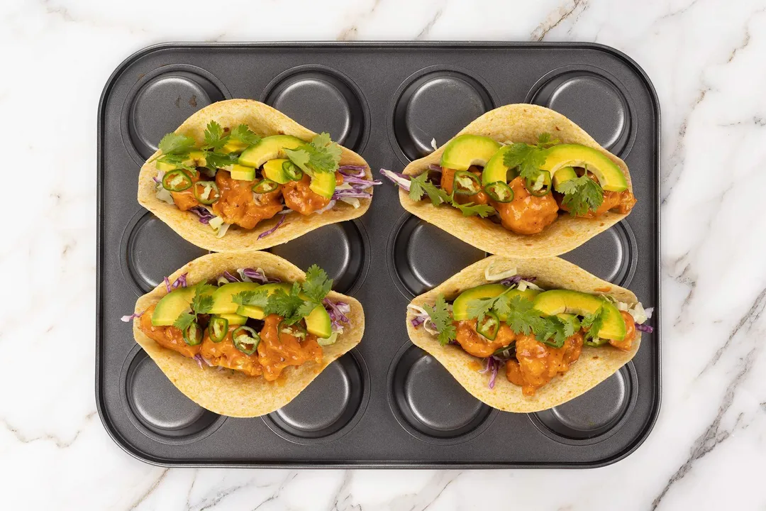 four tortillas filled with avocado slices, baked cauliflower florets, jalapeno, coriander