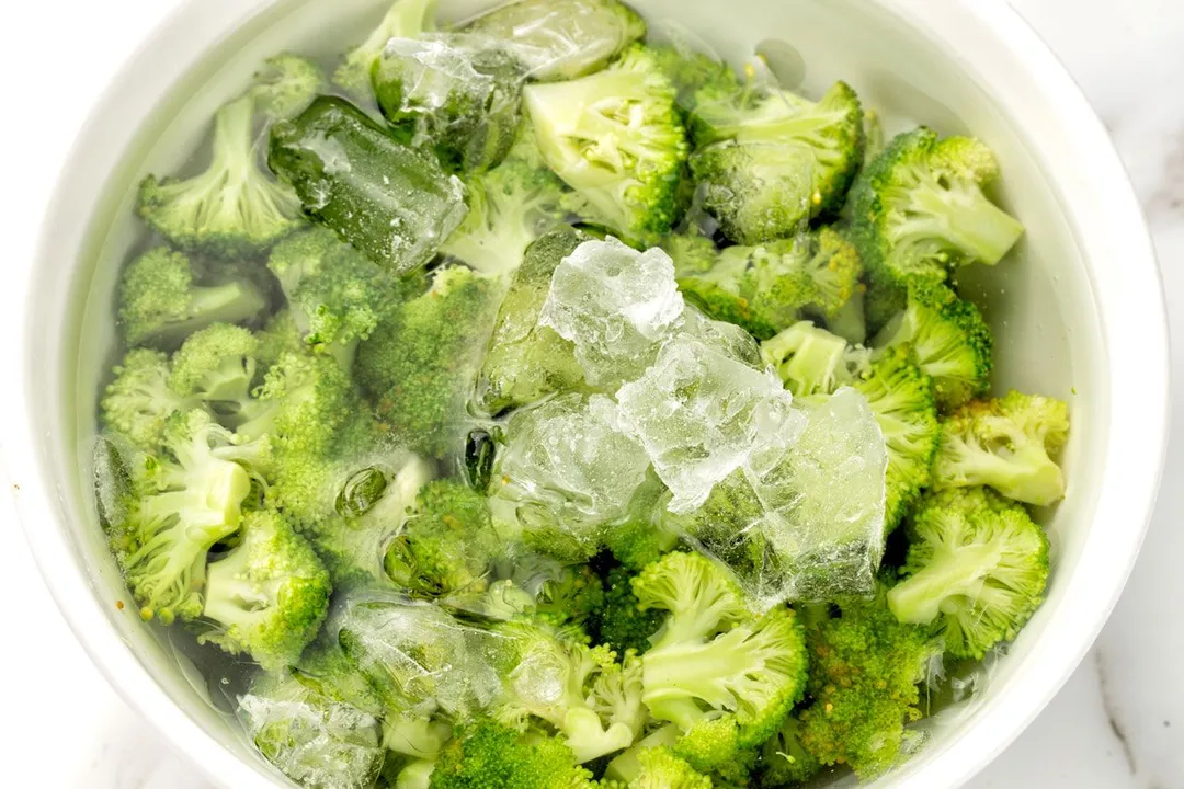 broccoli florets in a bowl with water and ice