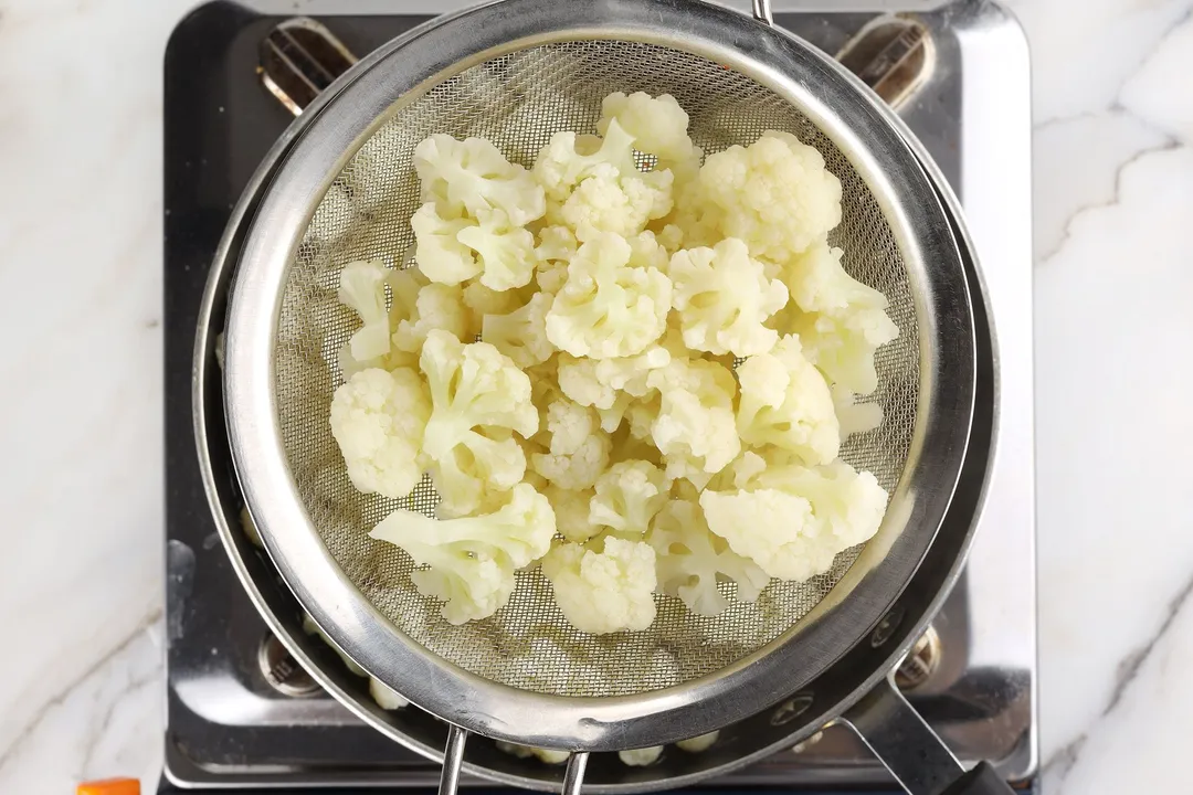 draining cooked cauliflower florets