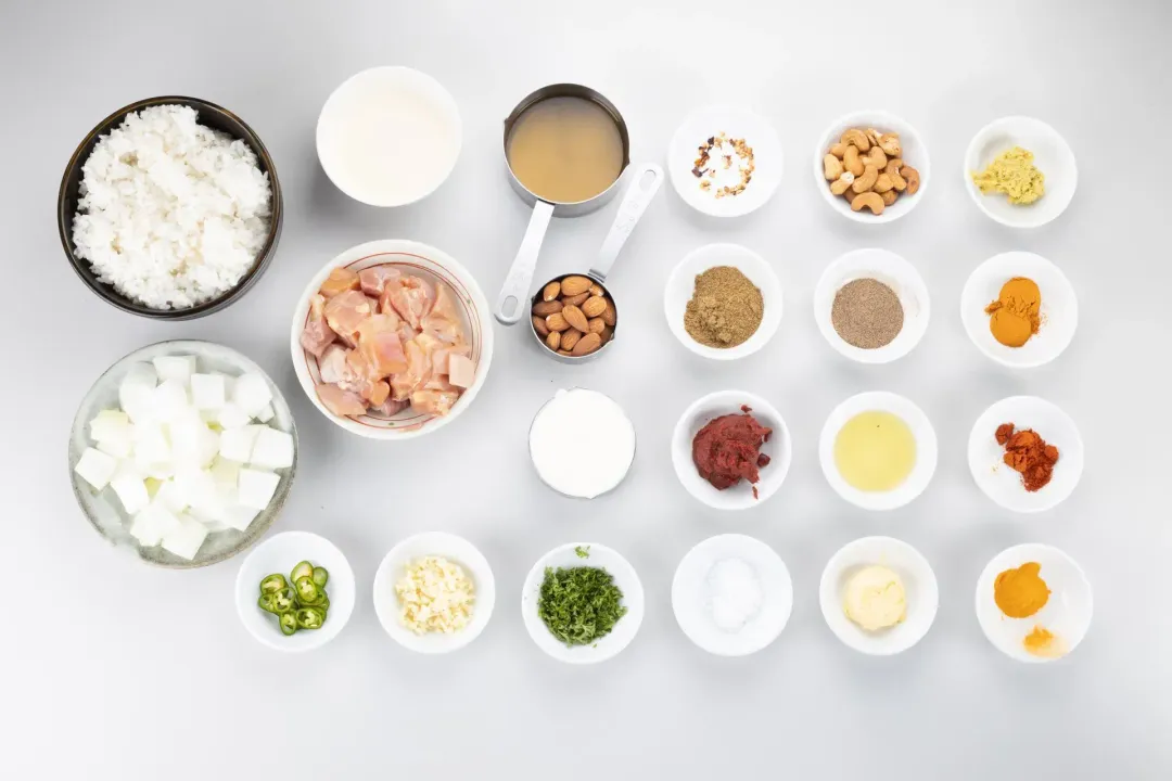 Ingredients: cooked rice, chopped onion, cut-up chicken thighs, and spices in different bowls