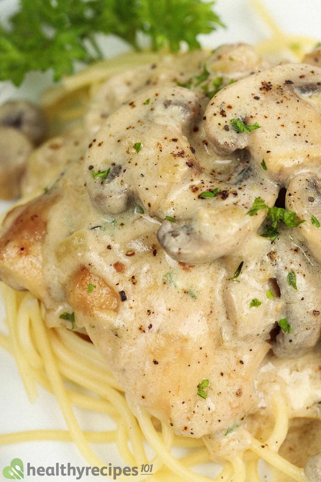 cooked chicken thigh with mushroom and sauce bed on pasta