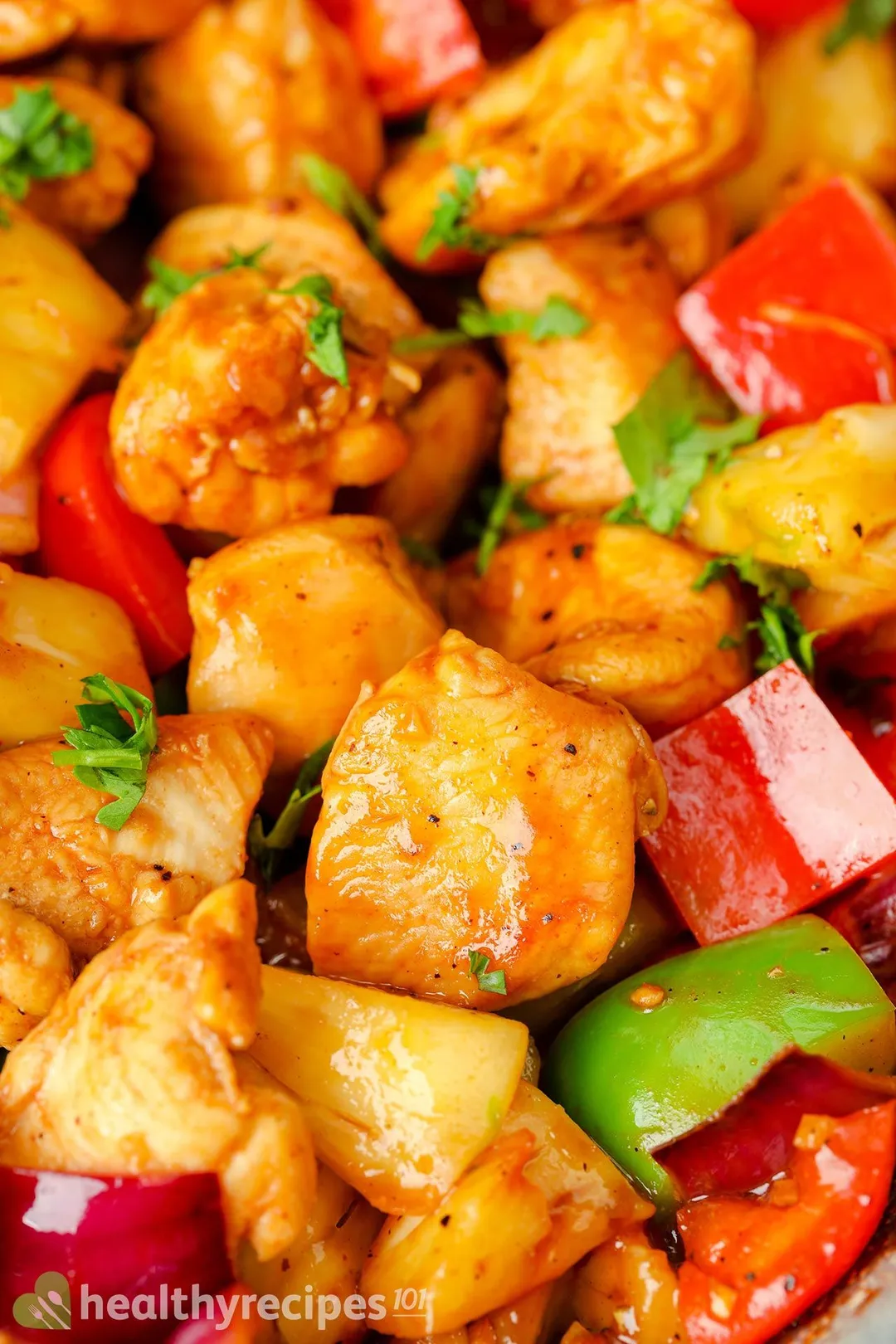 close-up shot of cooked cubed chicken with cubed bell pepper, garnished with cilantro