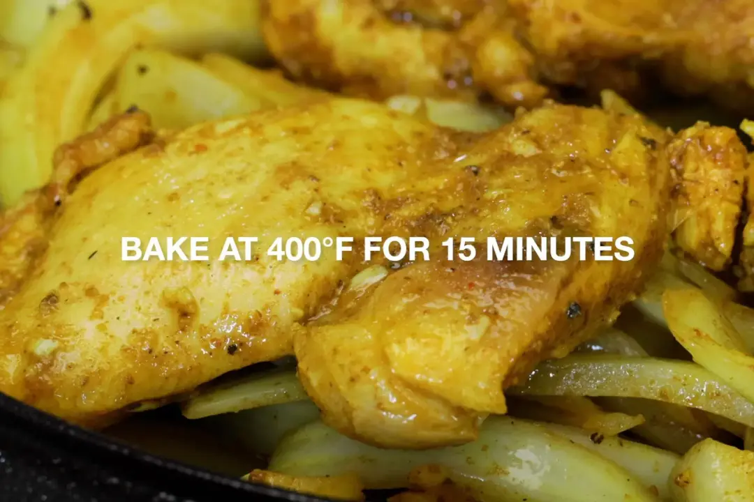 Golden pieces of chicken on top of cooked onion with a headline that reads “bake at 400°F for 15 minutes”