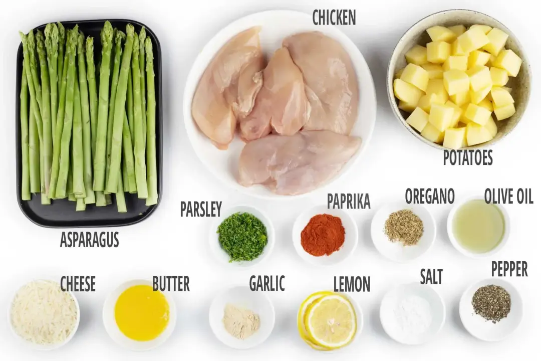 Plates of chicken breasts, potato cubes, asparagus stalks, lemon slices, and various condiments