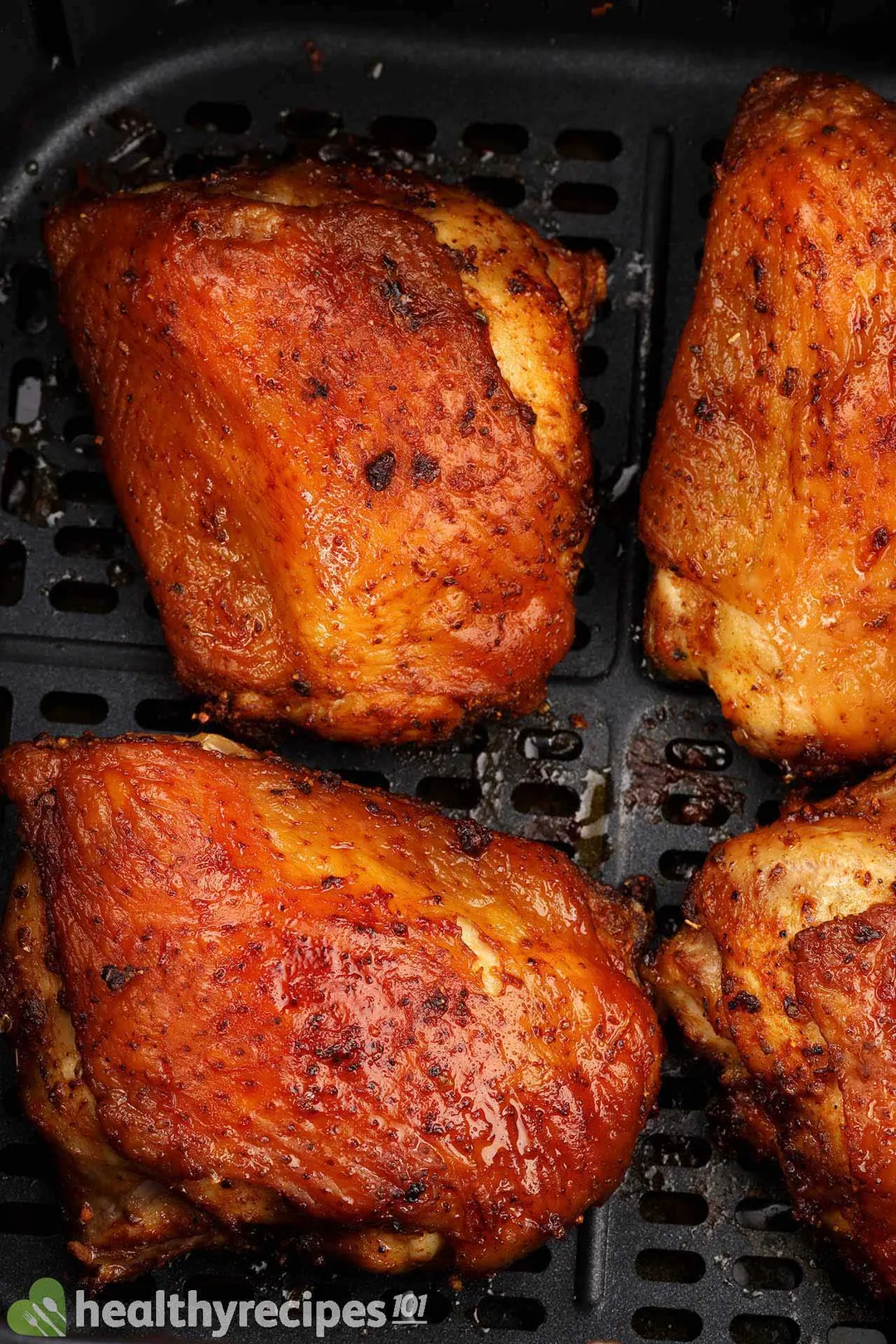 four cooked chicken thighs in an air fryer