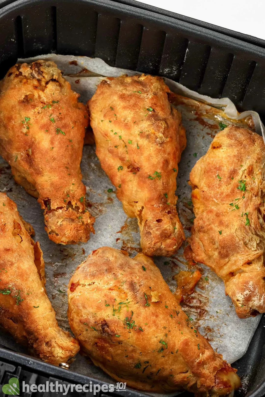 cooked chicken legs in an air fryer basket