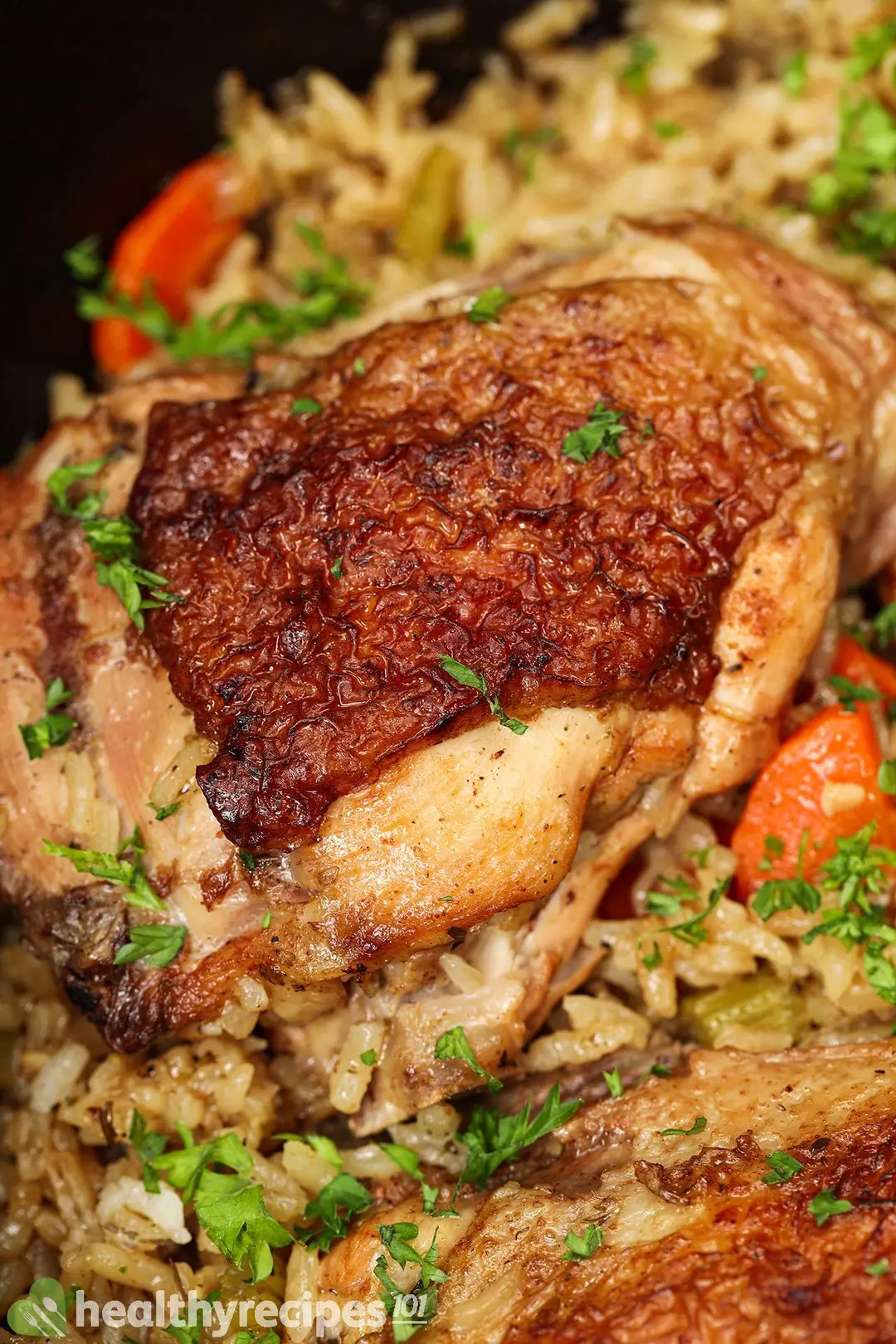 A close-up shot of a chicken thigh on top of cooked rice