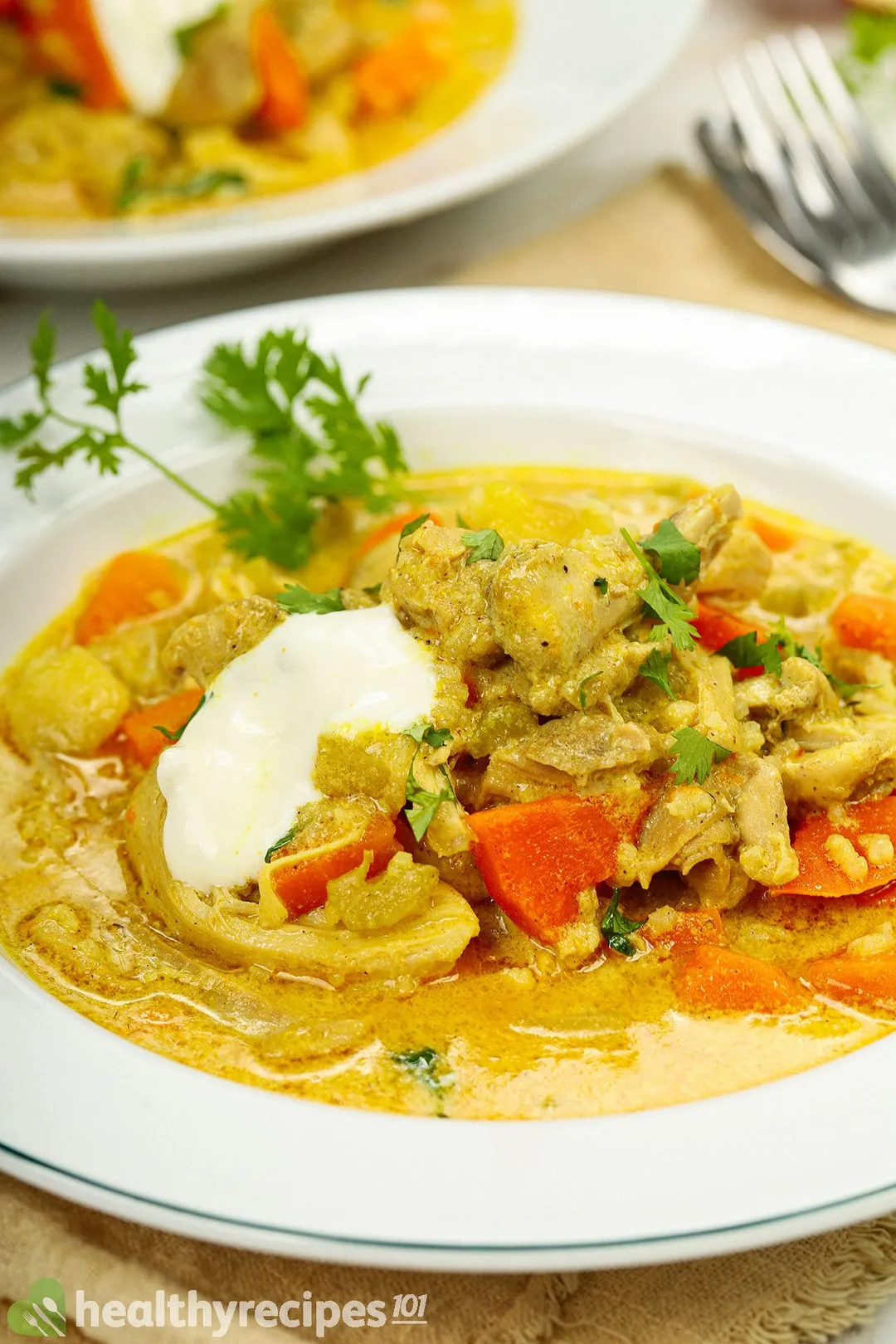 a plate of chicken soup with carrot and yogurt