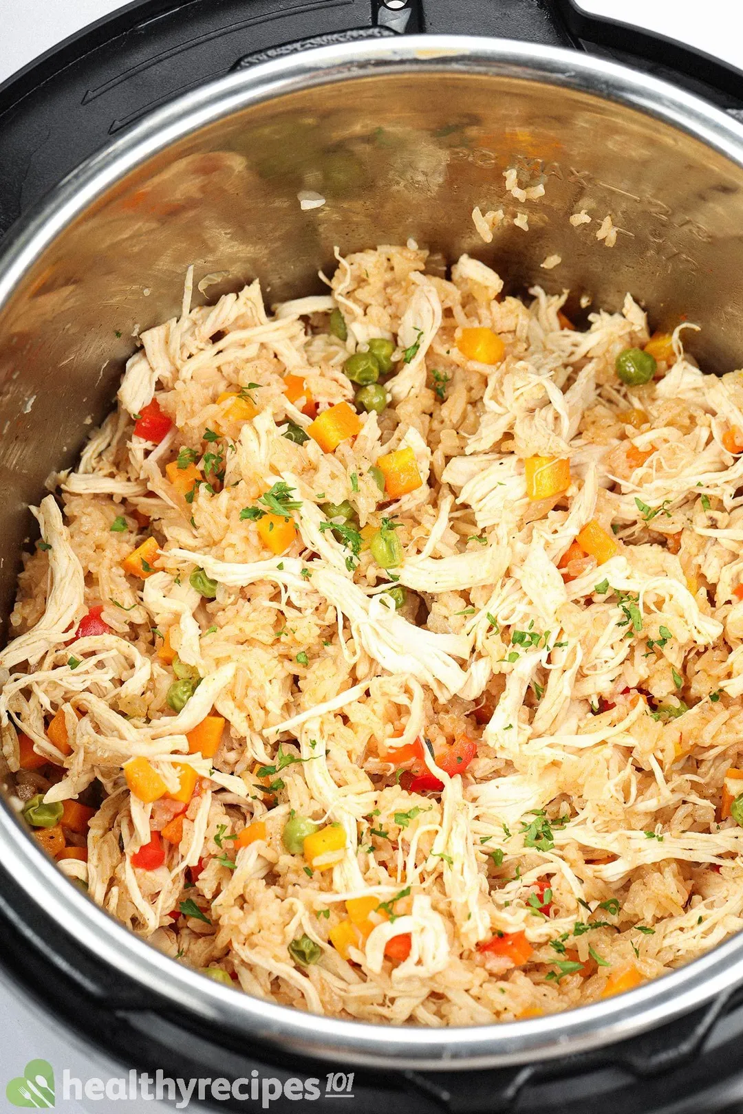 Rice cooked in an instant pot with shredded chicken, diced carrots, and green peas