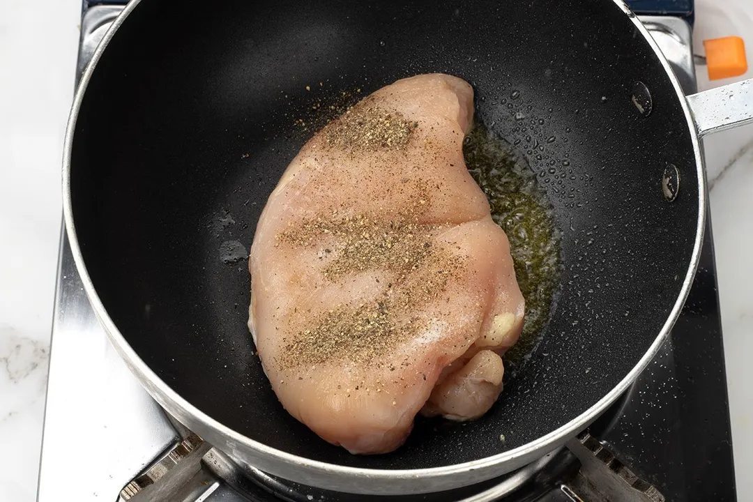 a chicken breast searing on a skillet