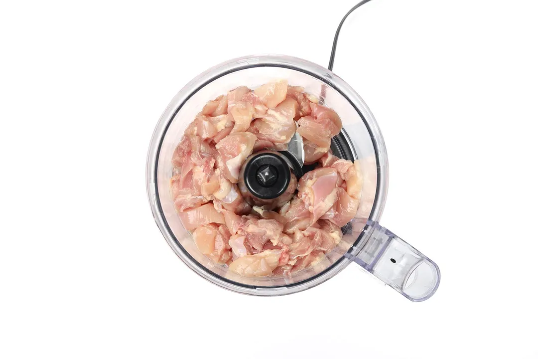 top view of chicken slices in a food processor