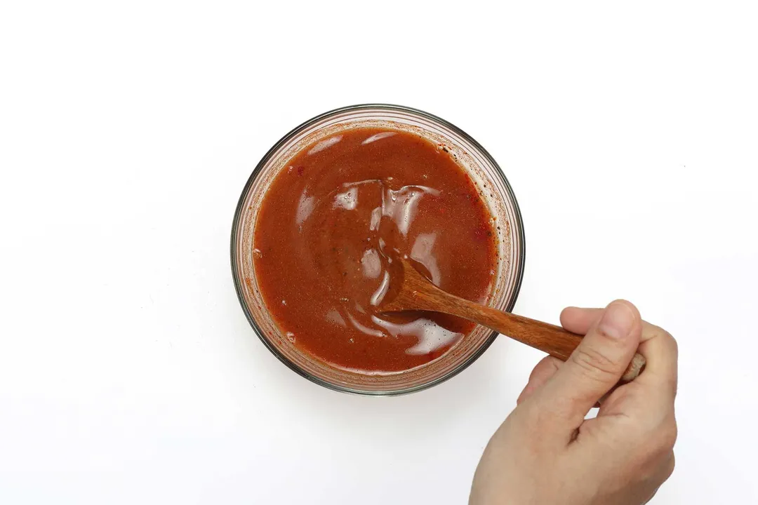 Buffalo sauce being mixed in a small bowl