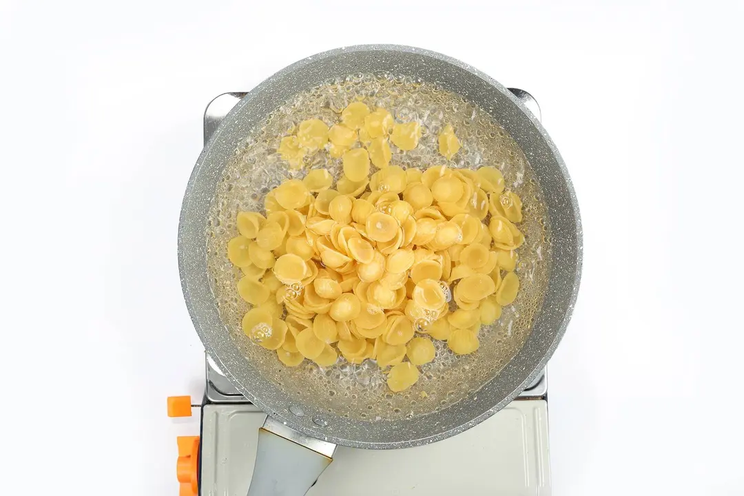 Orecchiette pasta being boiled in a pan
