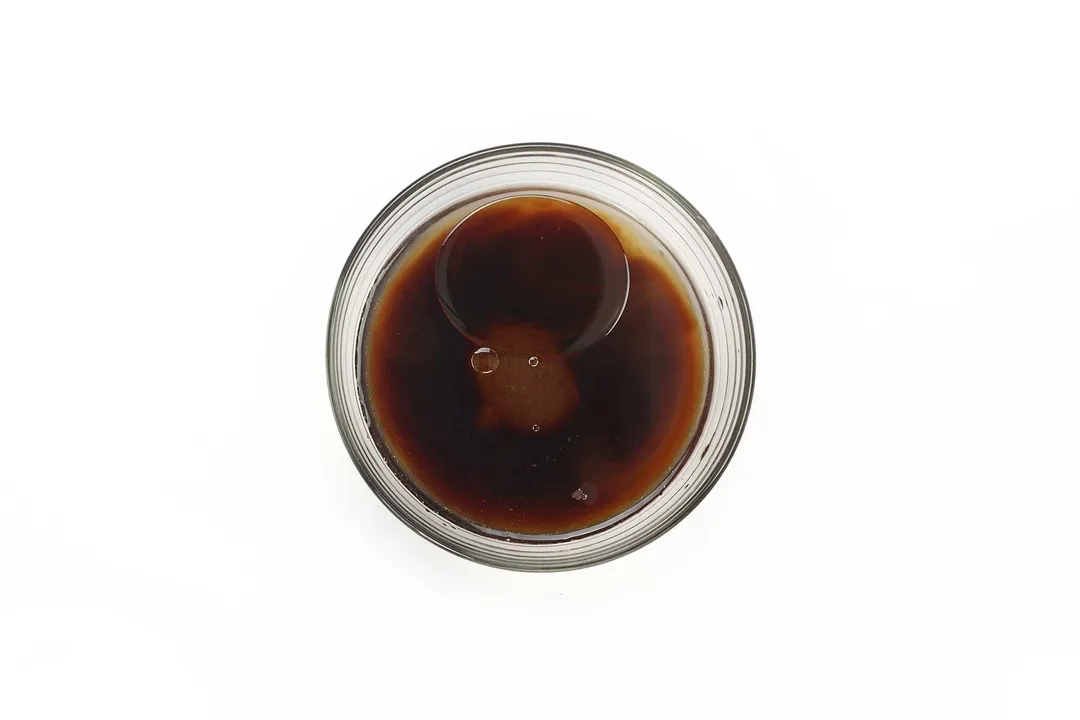 A small glass bowl containing a dark brown and glossy sauce