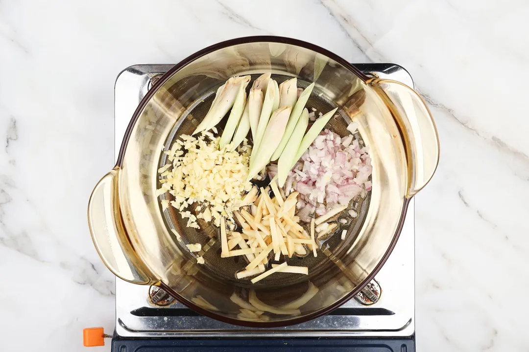 lemongrass, galangal, onion and garlic in a glass pot